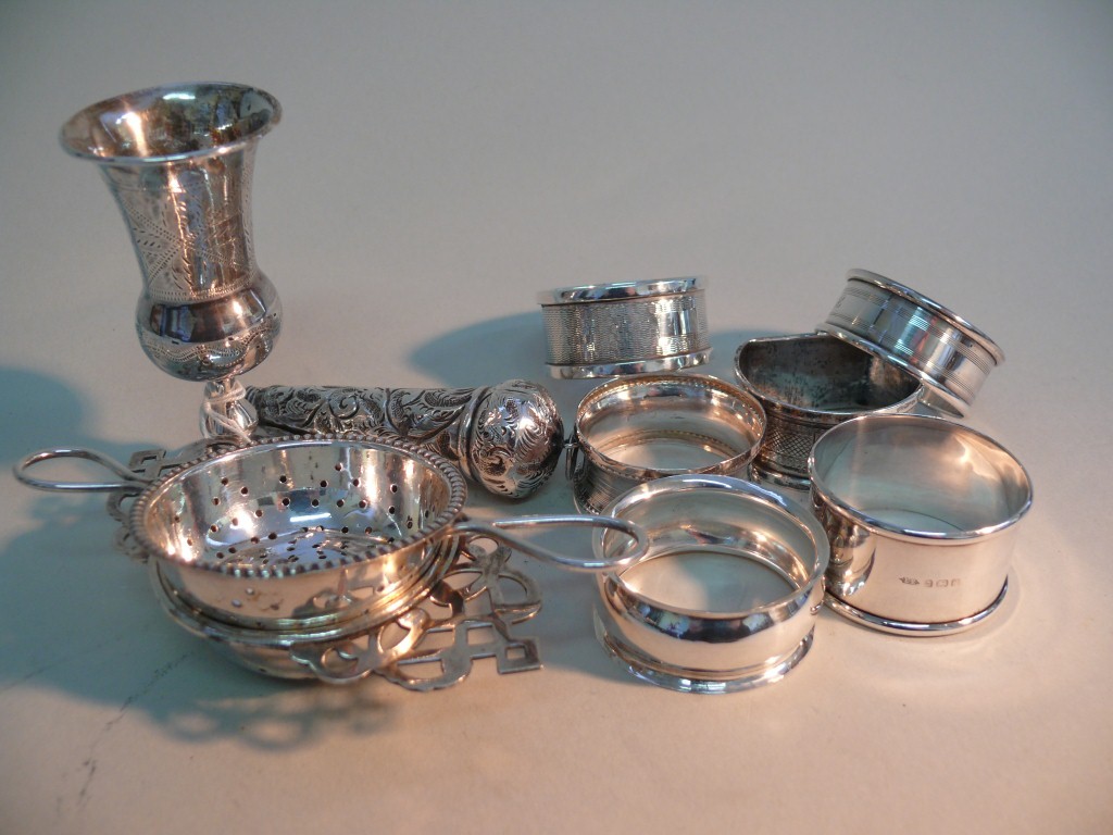 Six various silver napkin rings; together with two electroplated tea strainers; a silver miniature