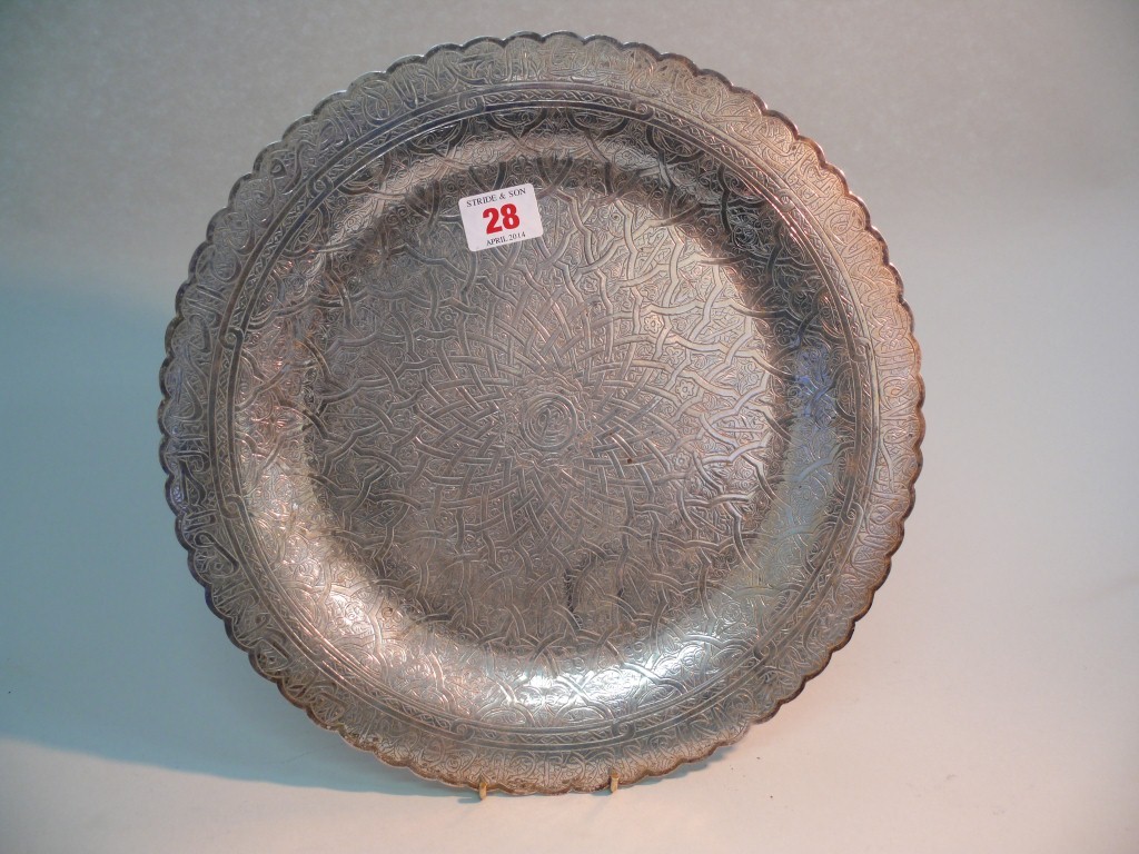 An Eastern white metal circular plate, having radiating Arabic decoration, 31cm.   Condition Report: