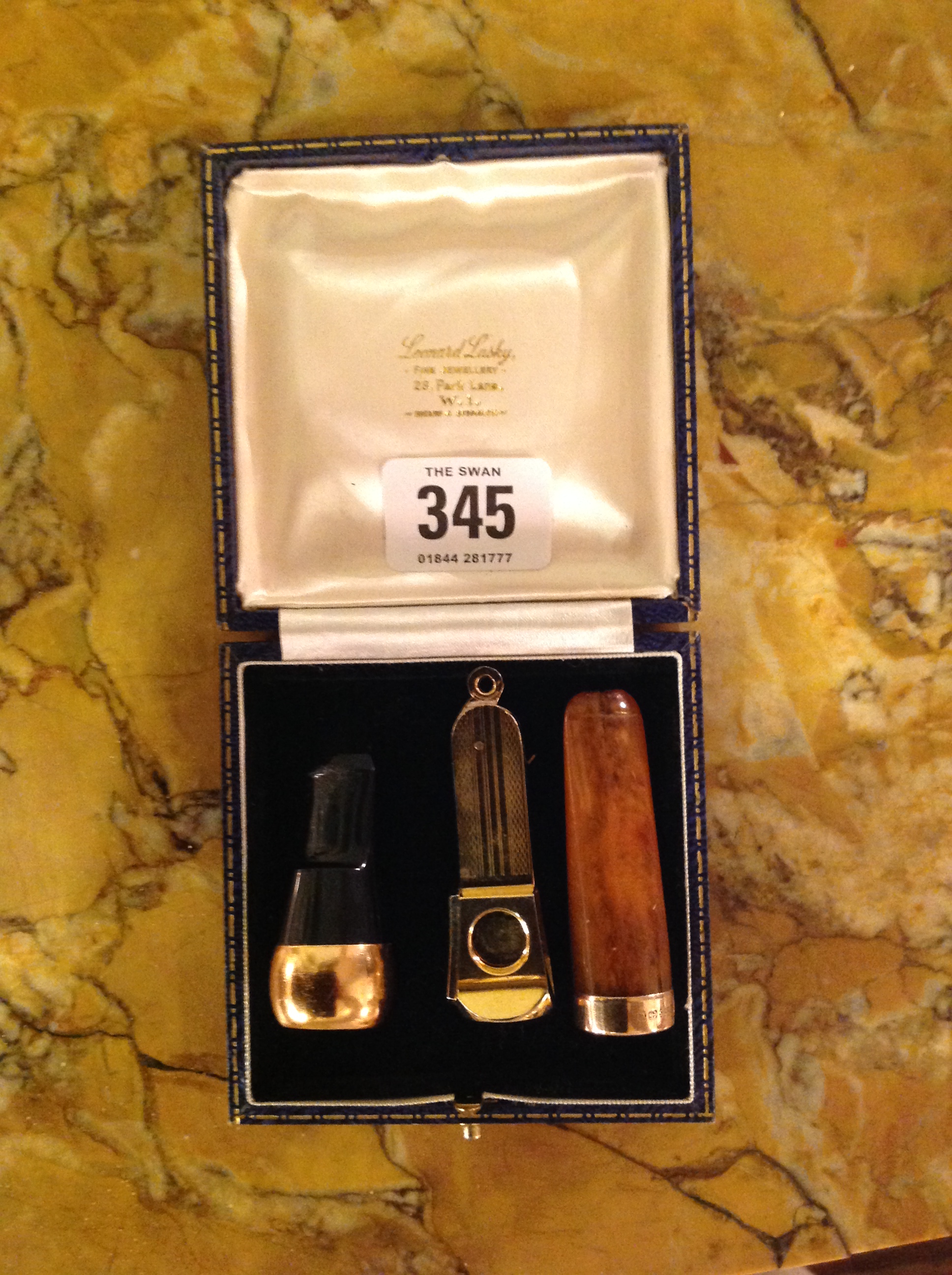TWO EARLY 20TH CENTURY GOLD MOUNTED CIGAR CHEROOTS Along with a yellow metal cigar cutter.