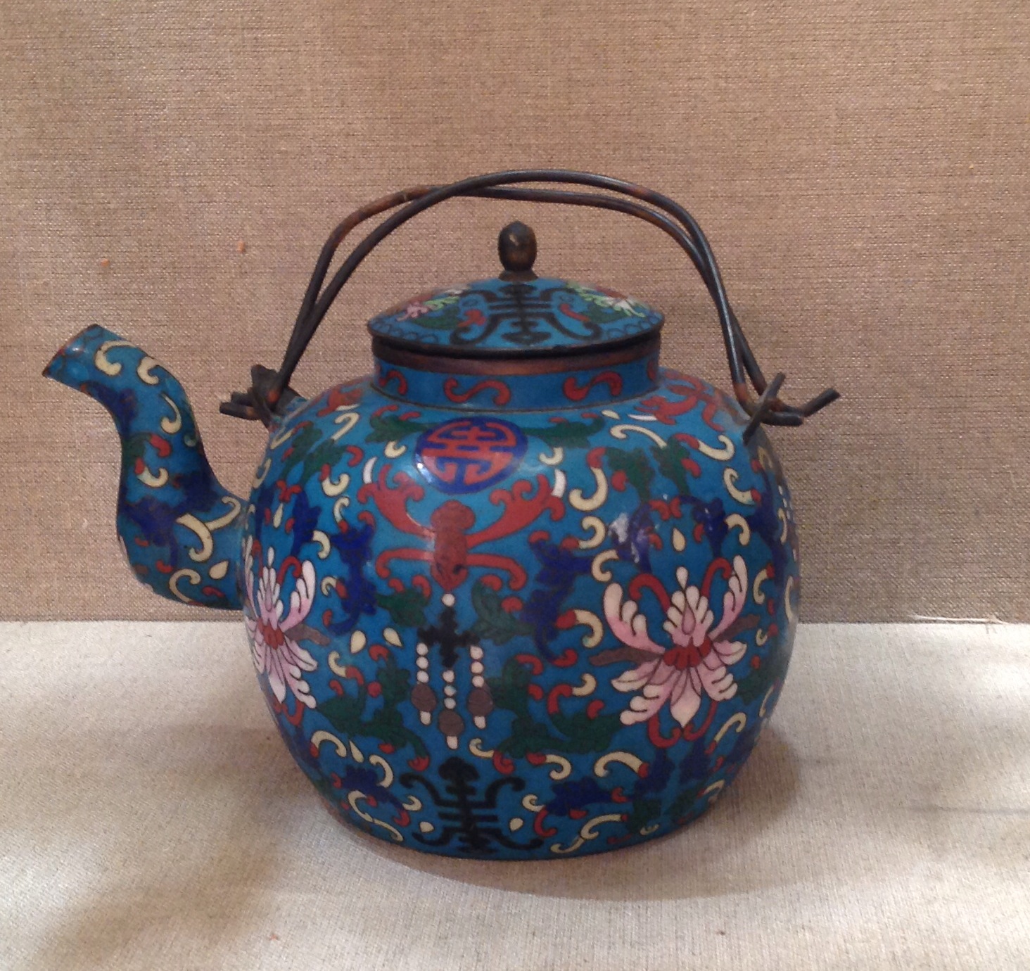 A CHINESE CLOISONNÉ TEAPOT With floral decoration on a duck egg blue ground and wire work handle. (