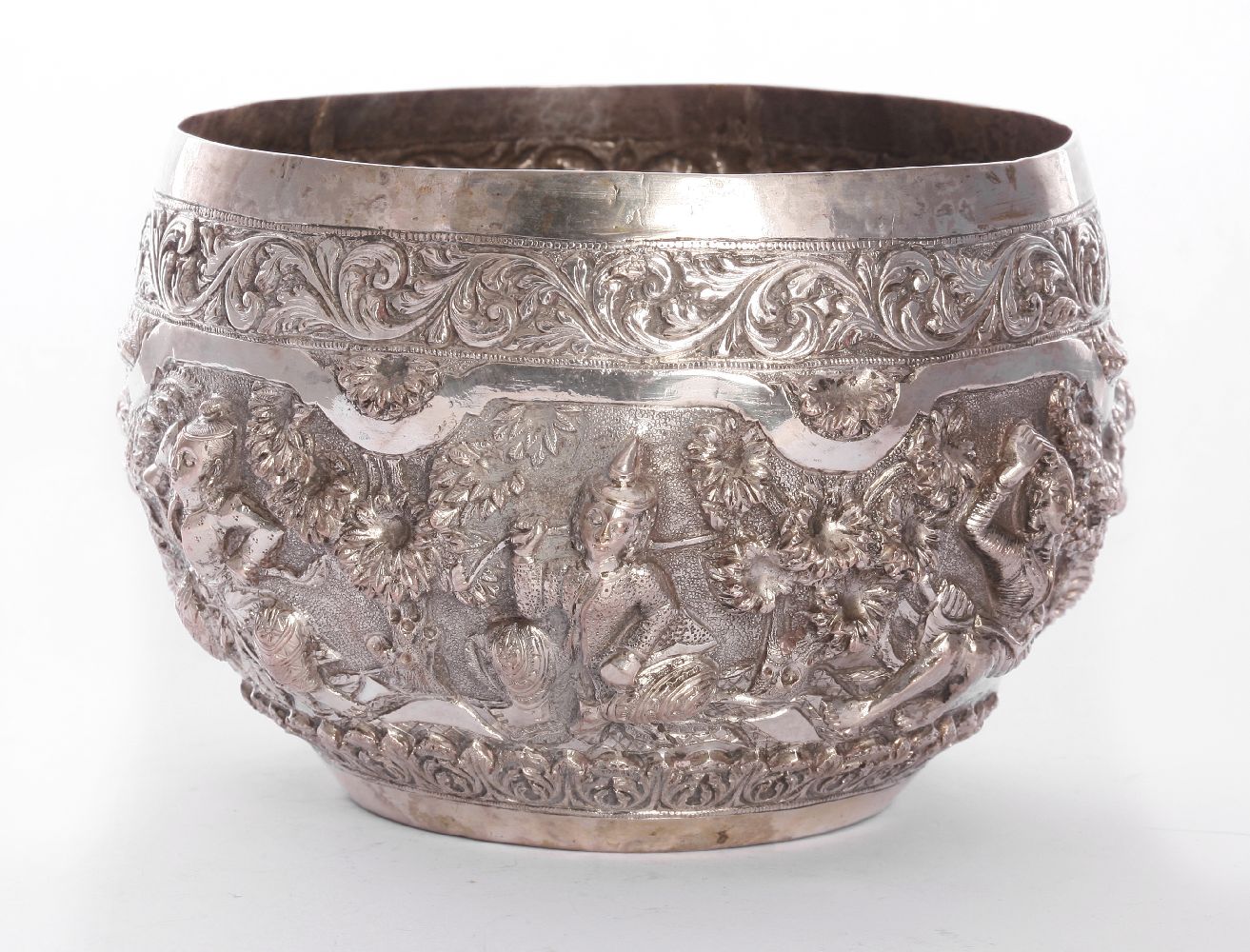 A Burmese silver bowl, late 19th century, of circular form decorated with a continuous scene of