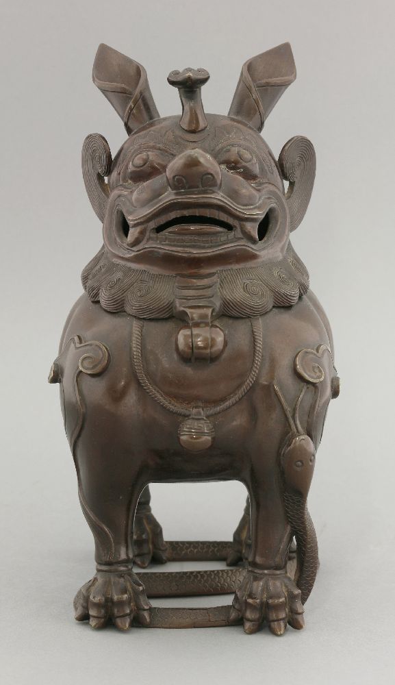 A bronze incense burner, 19th century, formed as a Buddhist lion with ruyi crest, hinging on the
