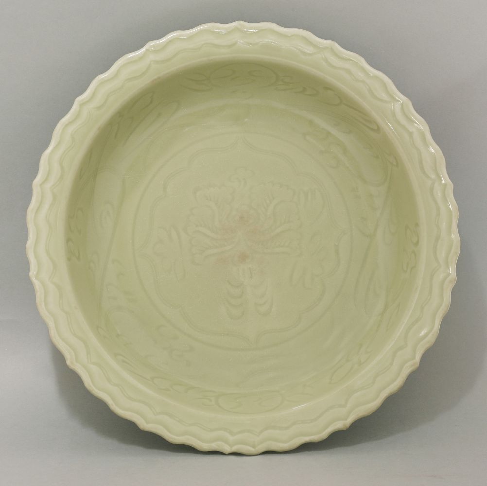 A Ming celadon Bowl,  early 15th century, with barbed rim, the centre impressed with a peony