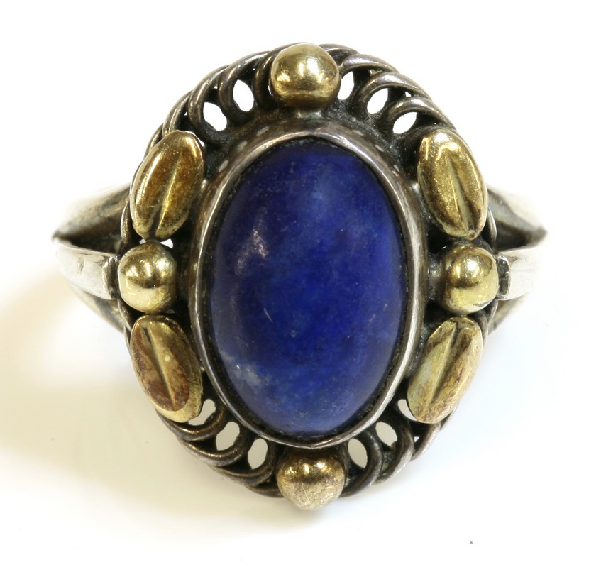 A cased silver lapis lazuli ring by Georg Jensen, No. 1A,
with an oval lapis lazuli cabochon, rub