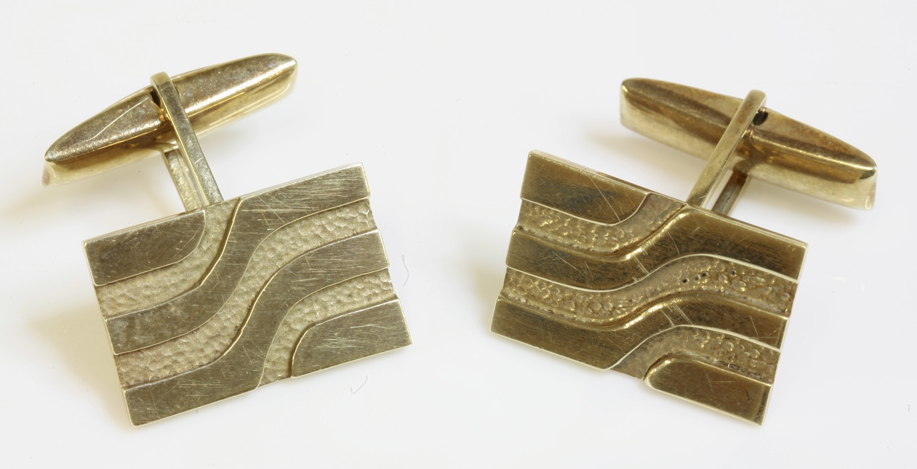 A pair of 9ct gold cufflinks,
with swivel fittings, rectangular heads, with waved grooved