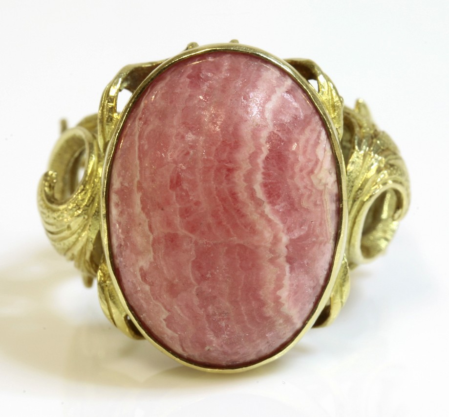 A Spanish single stone rhodochrosite gold ring, c.1960,
with an oval cabochon rhodochrosite, rub set