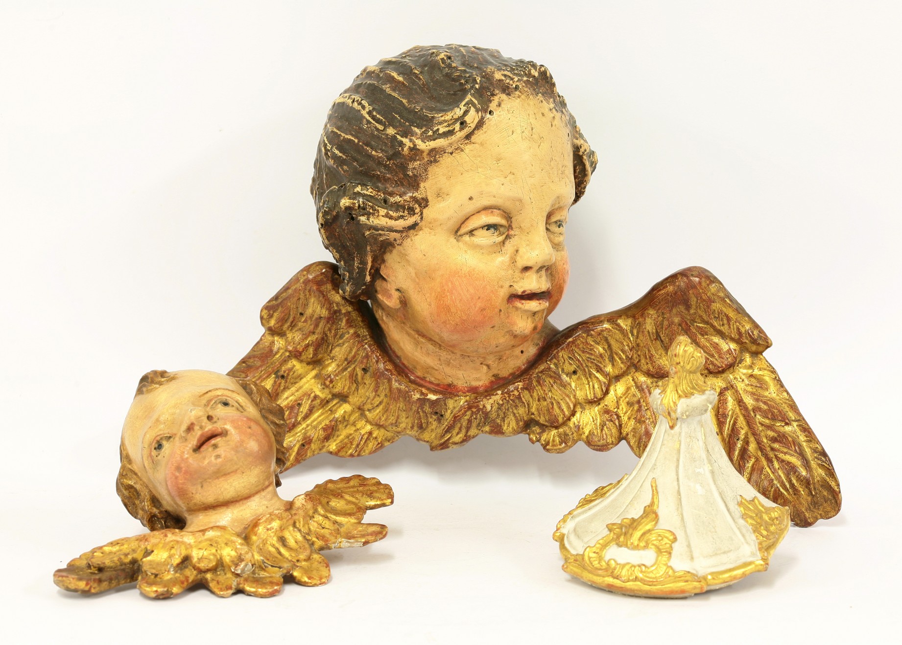 A German giltwood cherub appliqué,
19th century, 
17cm wide,
another similar appliqué,
26cm wide,