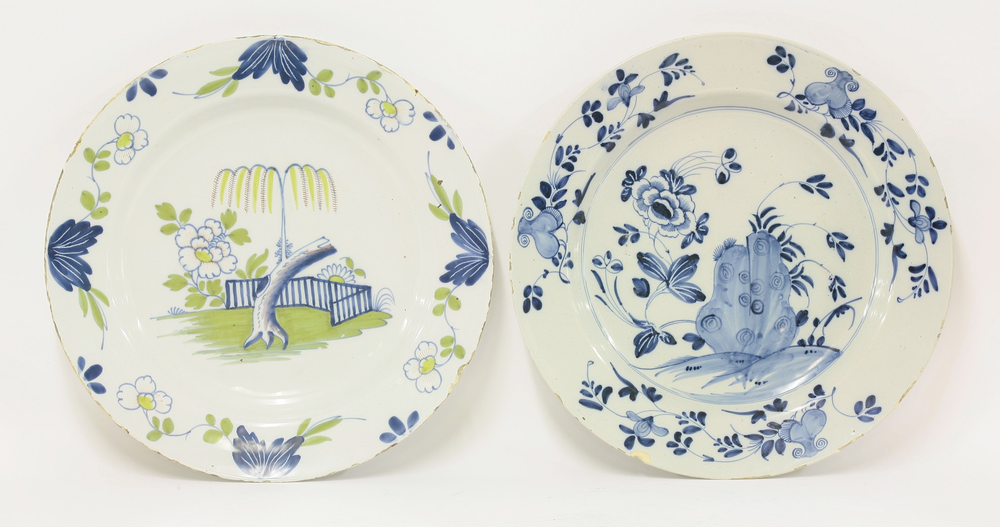 Two delft Dishes,
mid 18th century, both probably Bristol, painted with a willow growing from a