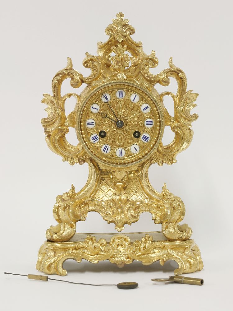 A good French ormolu bracket clock, ornately cast with scrolling foliage, the dial with porcelain