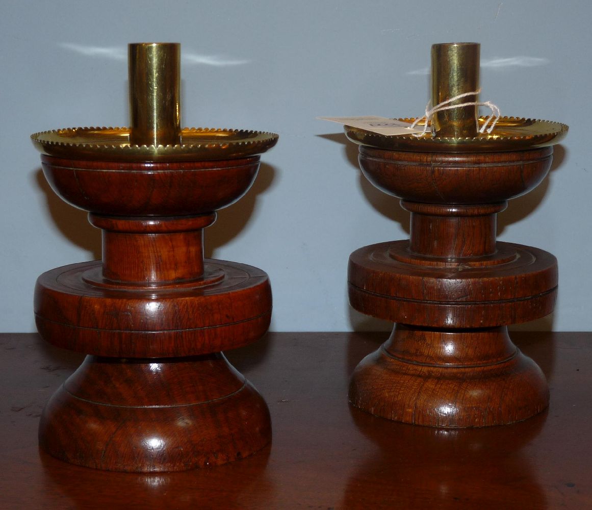 A pair of oak and brass candlesticks, 19cm high