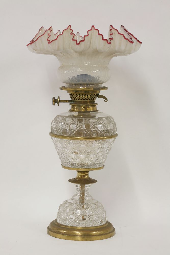 A Victorian glass oil lamp, with brass mounts, hobnail cut reservoir and base, now with a frilled