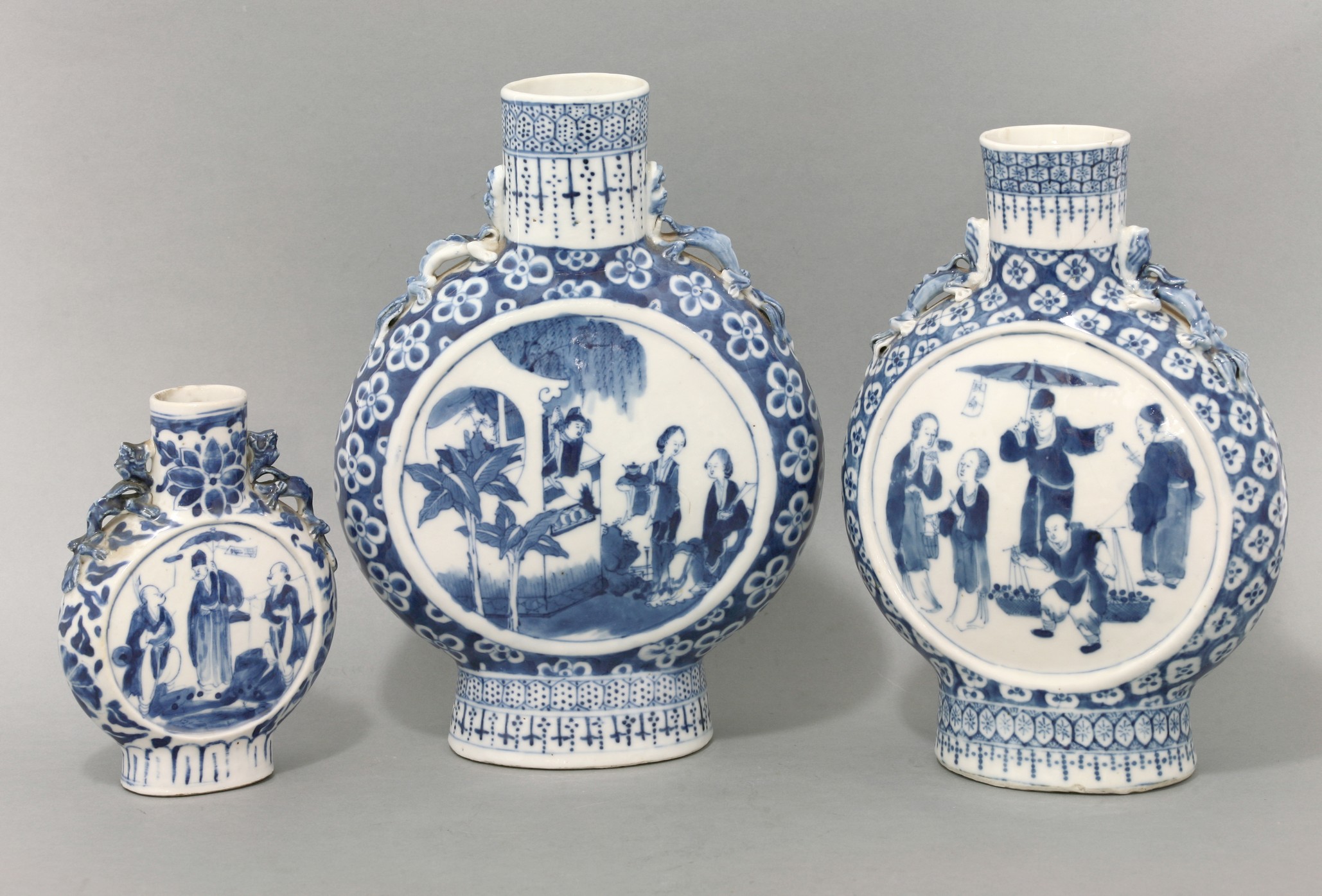 Three blue and white Moon Flasks,
late 19th century, one with a scene from 'The Western Wing', the
