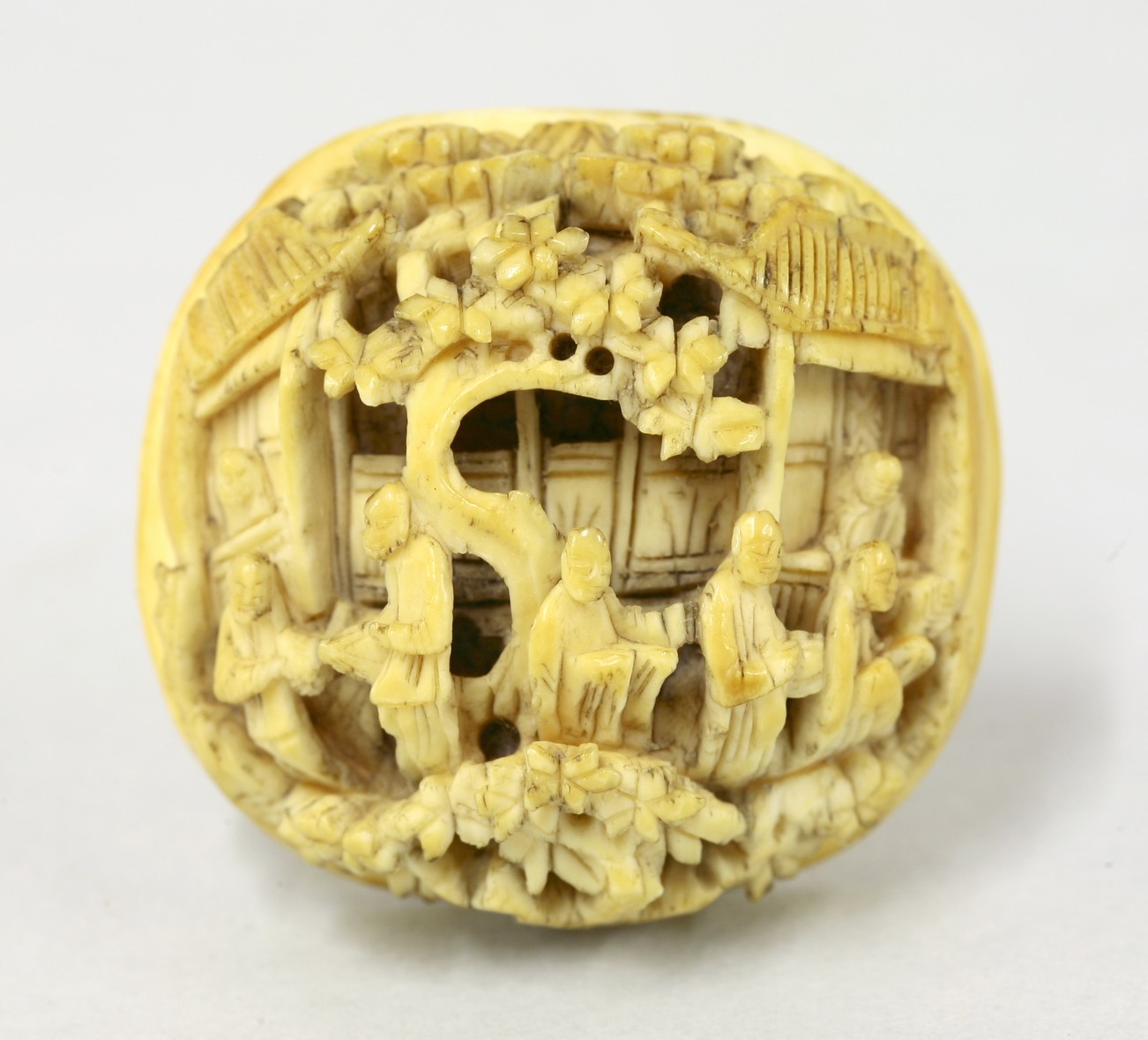 A Canton ivory Brooch Cabochon,
mid 19th century, carved and undercut with figures between trees and
