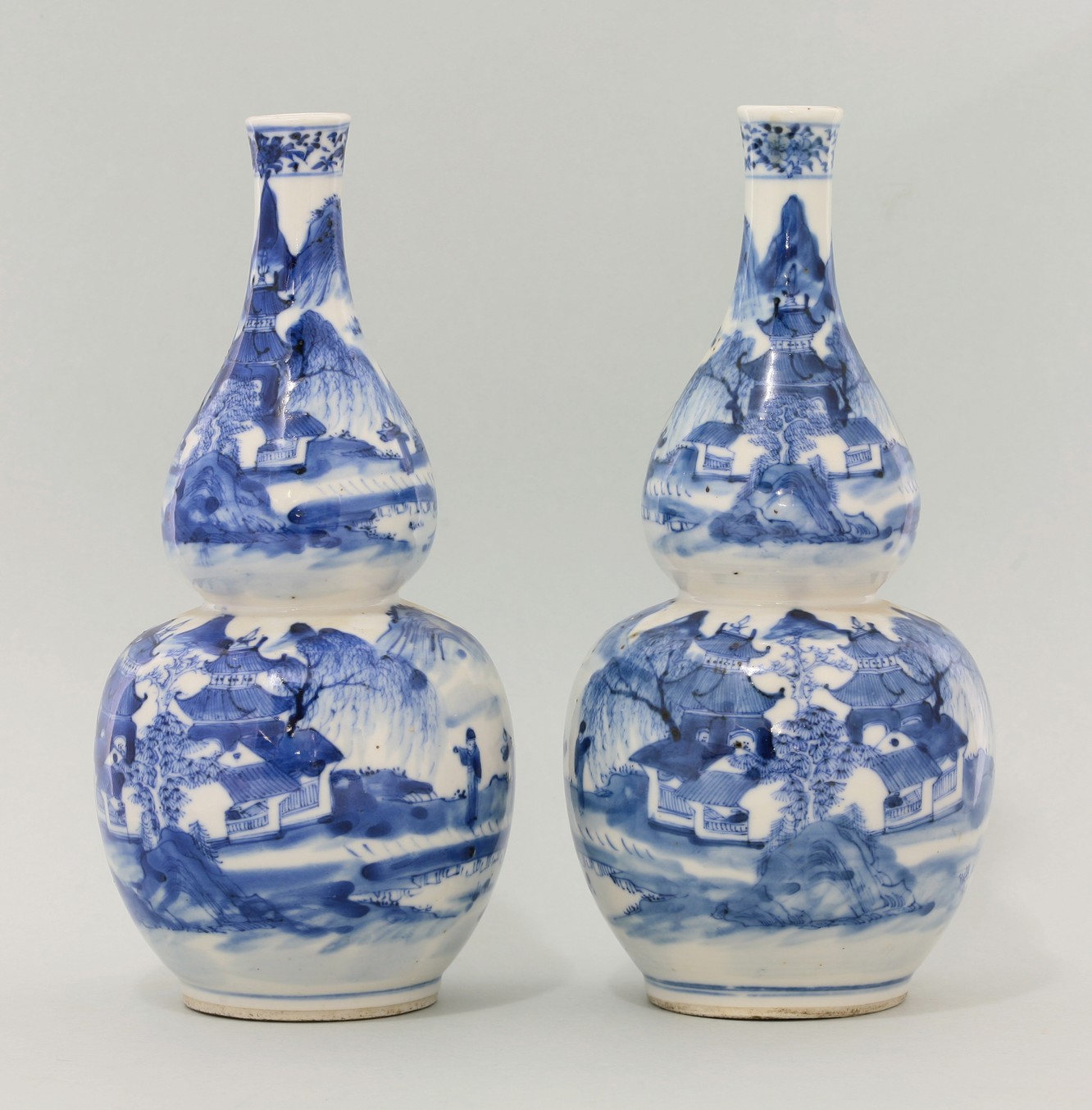 A pair of blue and white double-gourd Vases,
c.1880, each painted with pagodas and figures in a