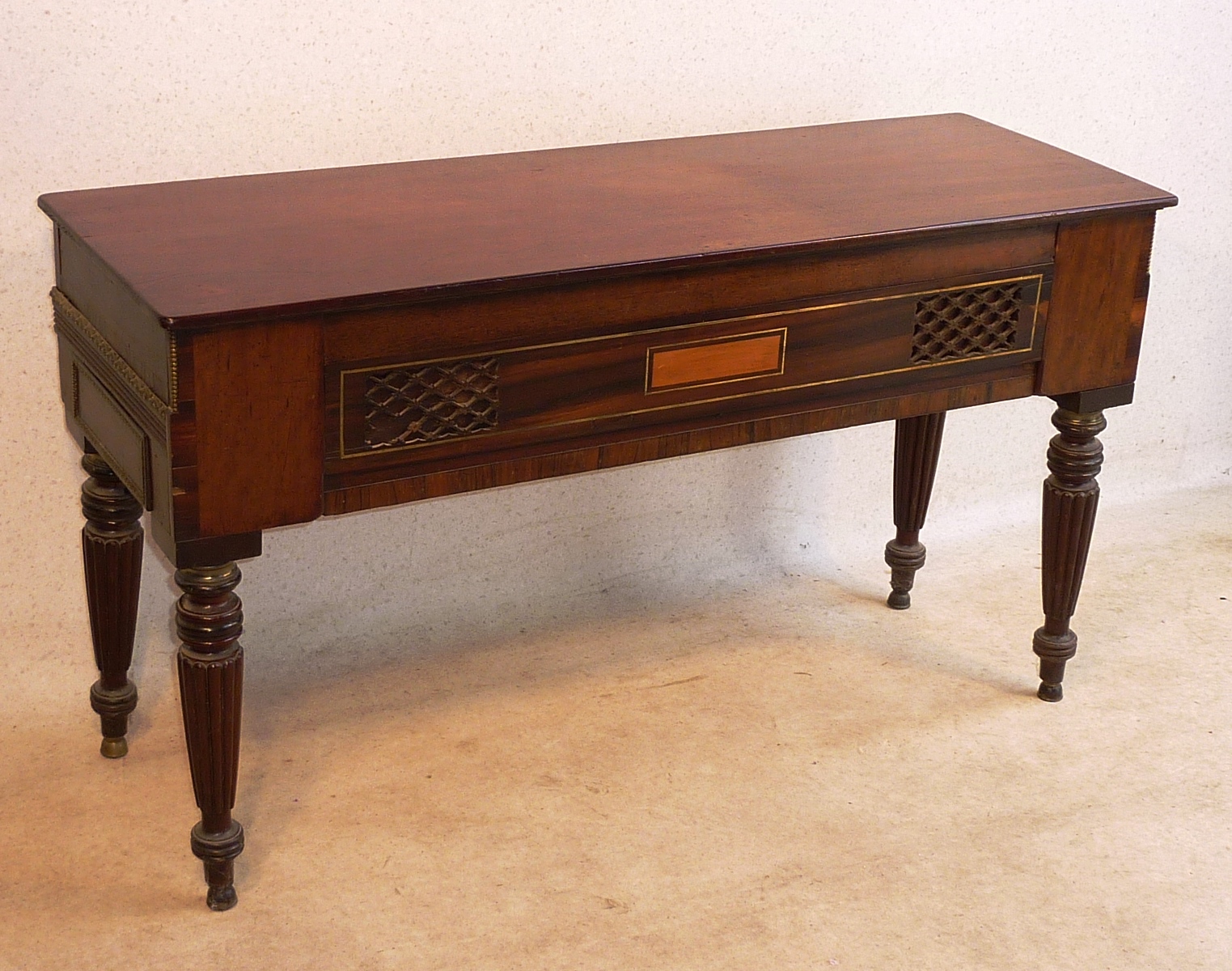 An early 19th Century Regency period mahogany Spinette raised on four turned tapering reeded legs