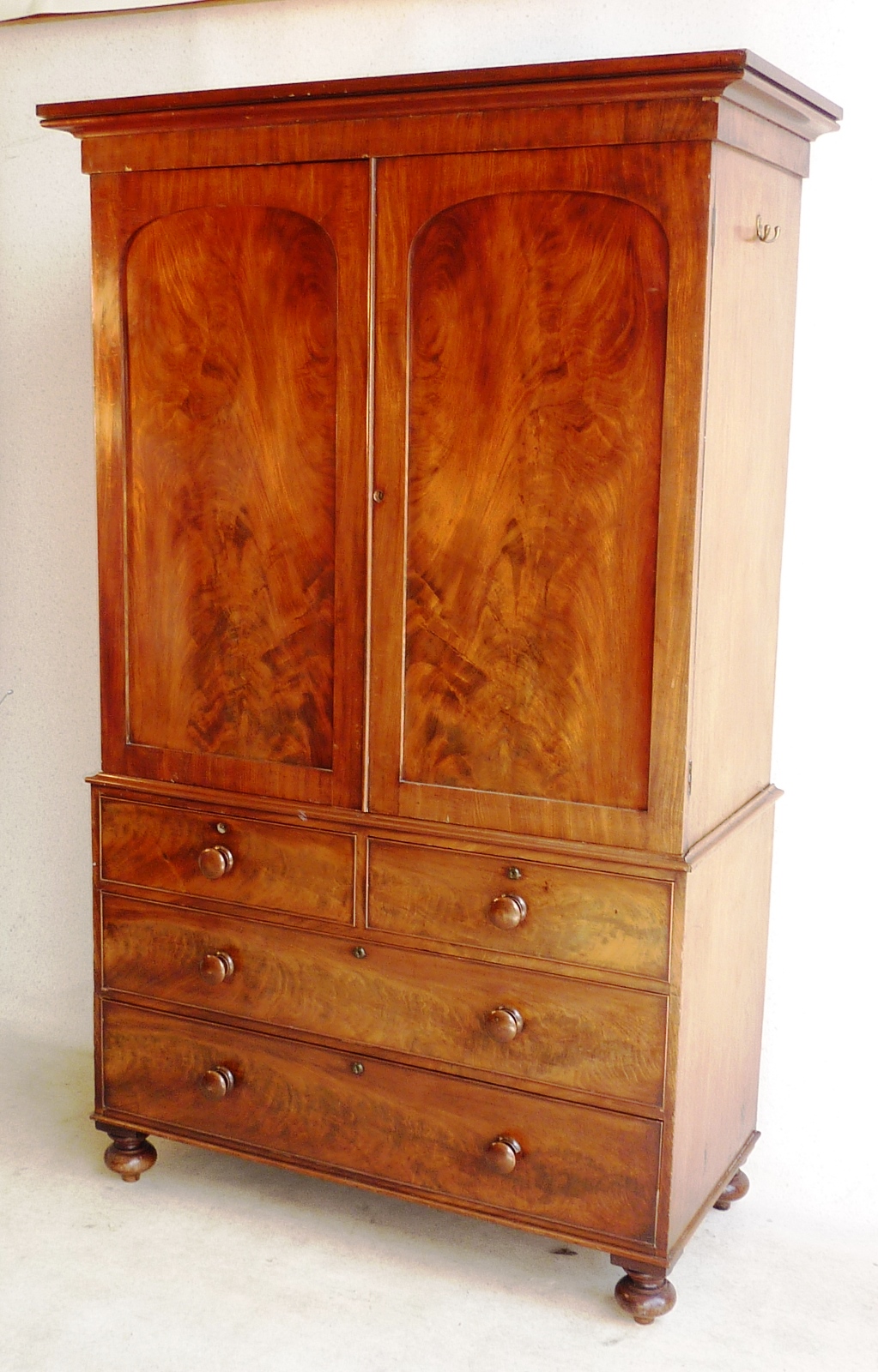 A large mid 19th Century mahogany Linen Press, flaring cornice above two arched flame mahogany