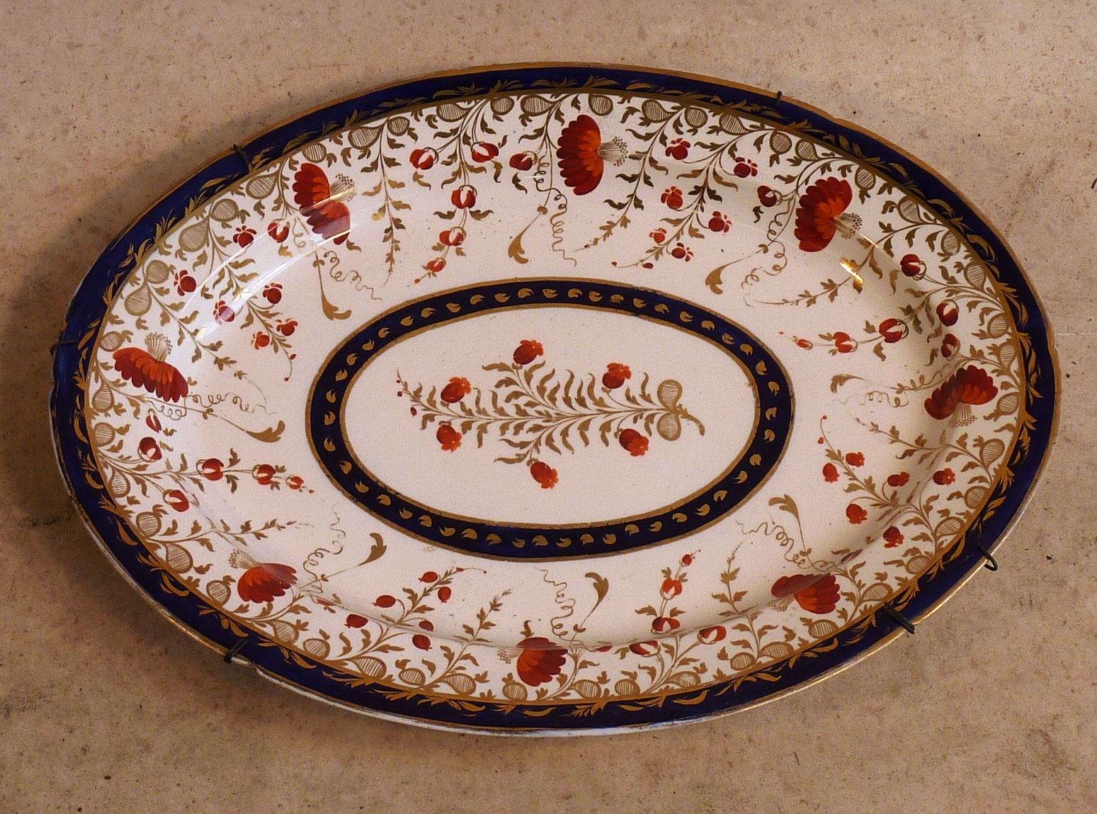 A large early 19th Century oval Platter hand gilded and decorated in the Imari palette