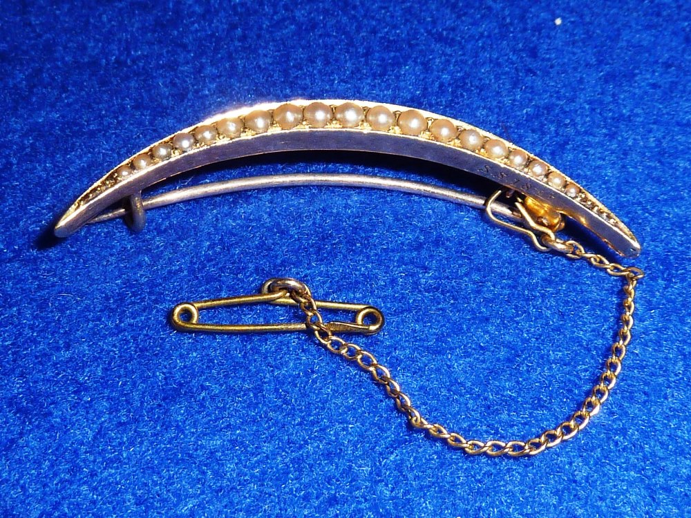 An early 20th Century 18 carat yellow gold crescent shaped Brooch and safety chain, the brooch set