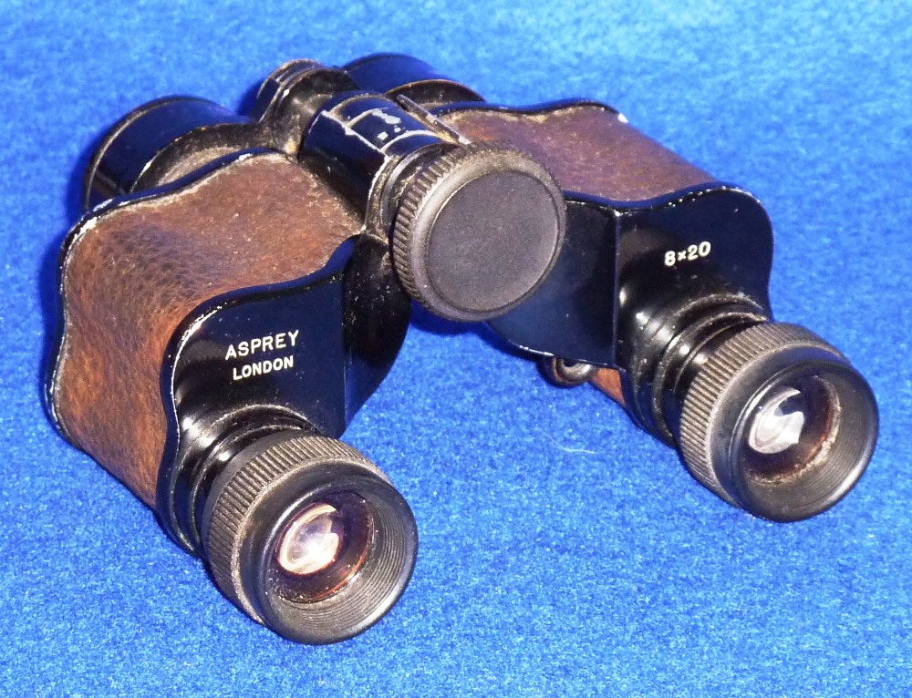 A small pair of folding French Field Glasses retailed by Asprey & Co., London (8x20 magnification)