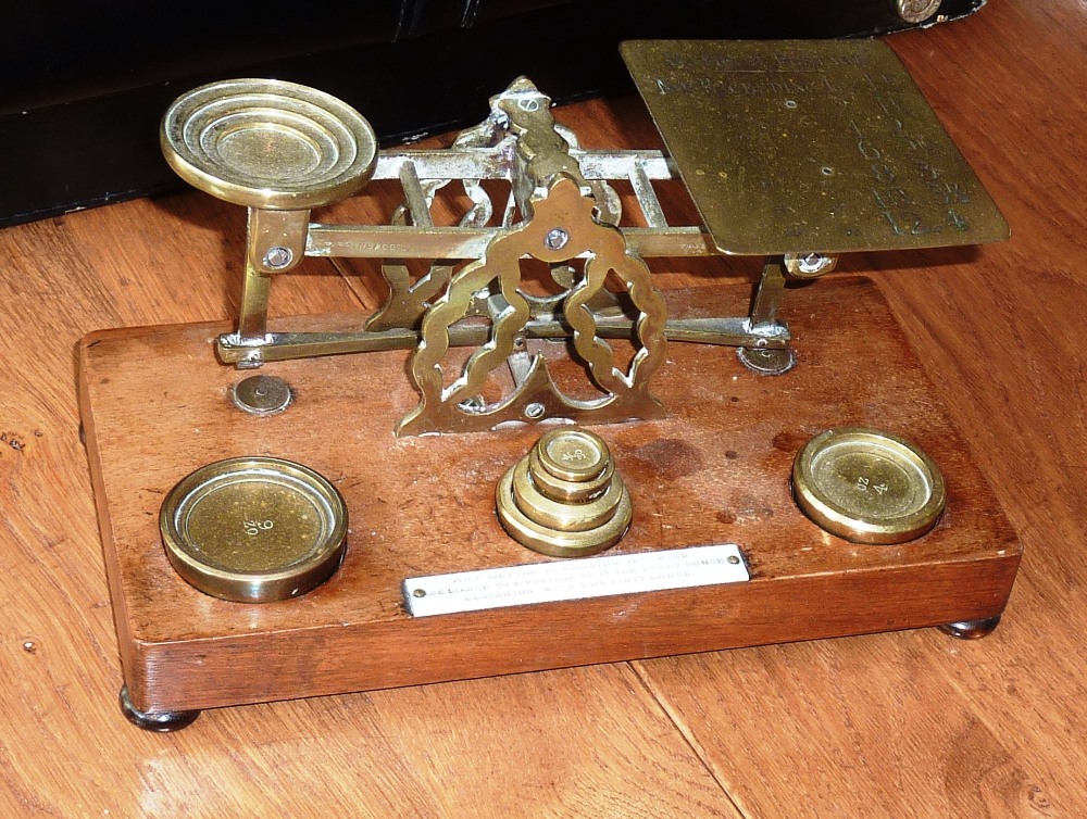 A late 19th/early 20th Century set of brass Postal Scales on a rectangular mahogany plinth base with