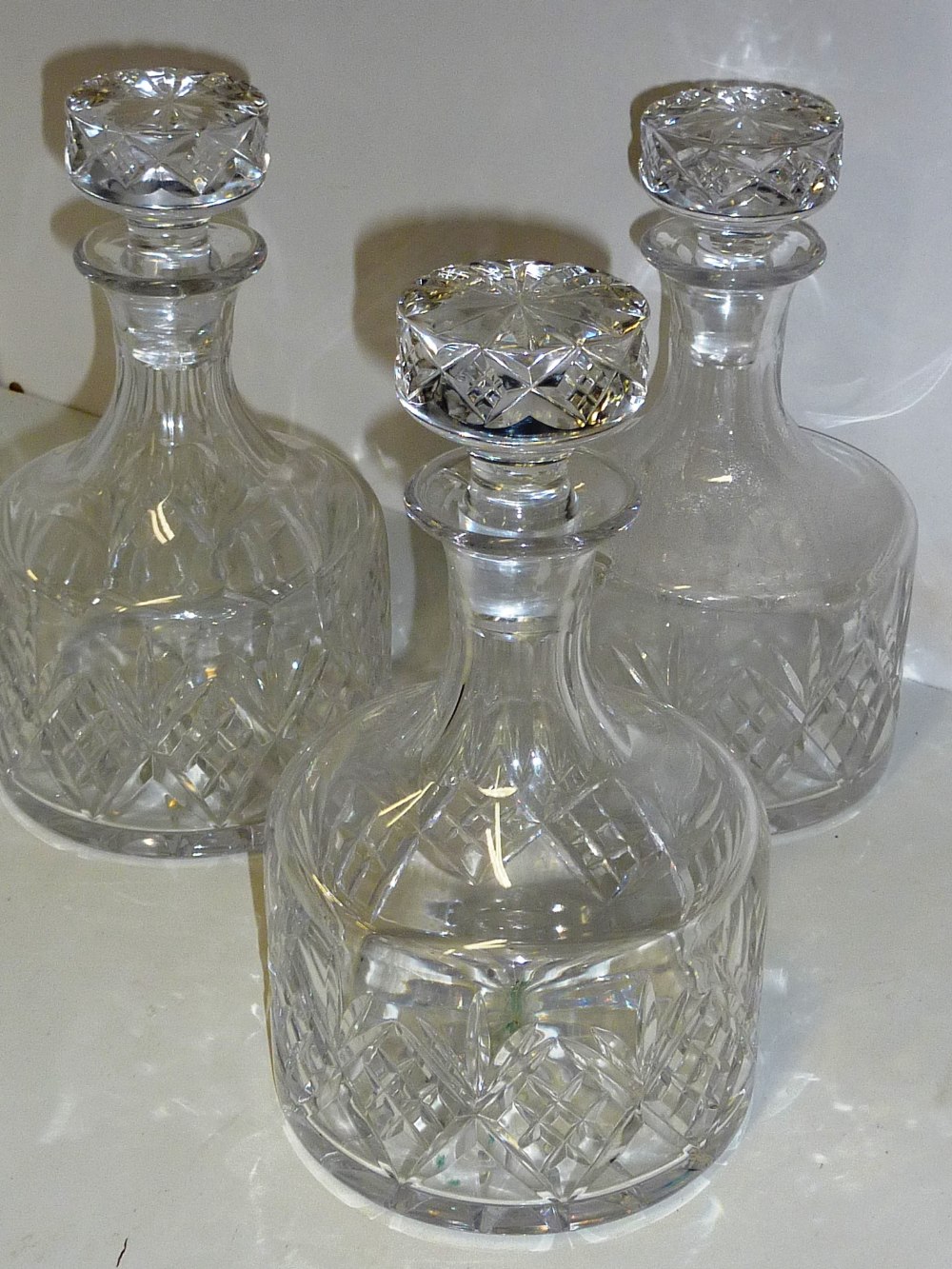 A set of three mallet shape cut glass Decanters and Stoppers