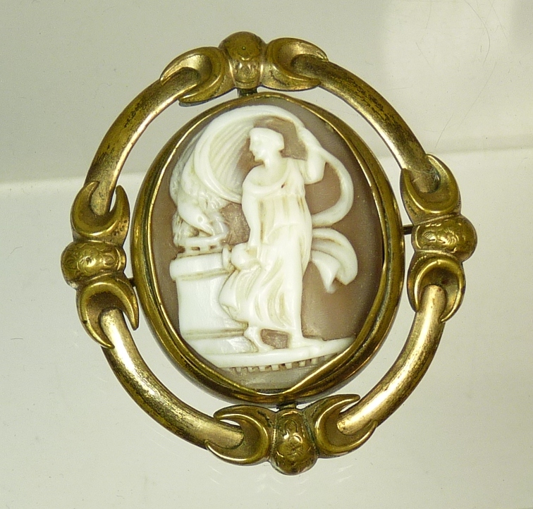 A Victorian cameo memorial brooch, in gilt metal mount, carved with image of Hebe and Zeus as the