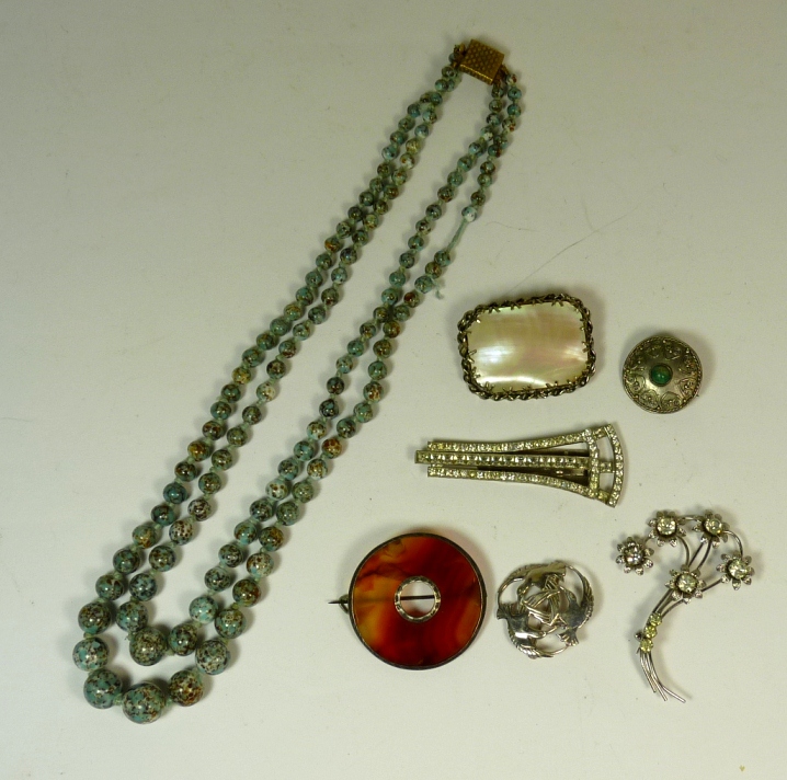An agate target brooch; a circular seagull brooch, tests as silver; a double strand bead necklace