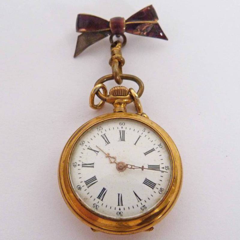 LADIES FOB WATCH IN CASE MARKED 230 WITH ENAMELLED BOW BADGE