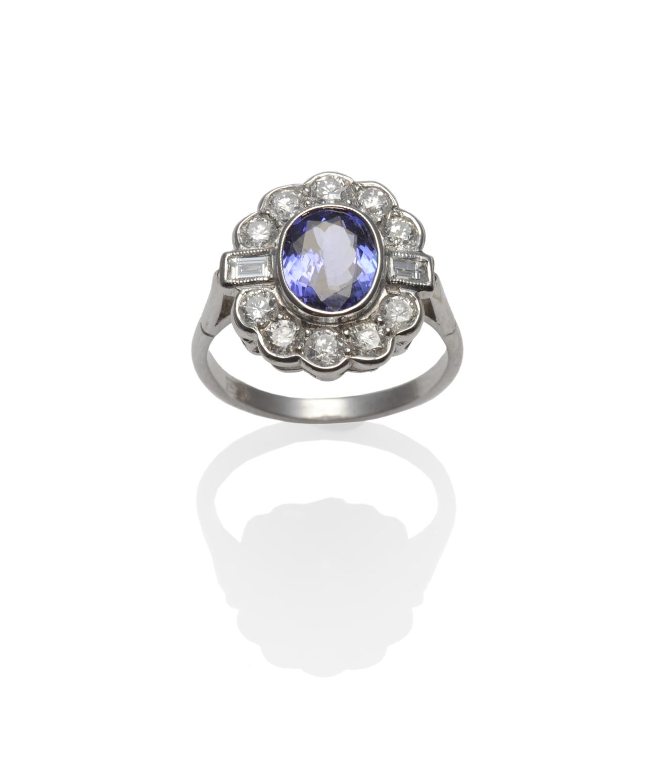 A Tanzanite and Diamond Cluster Ring, an oval cut tanzanite within a border of round brilliant cut