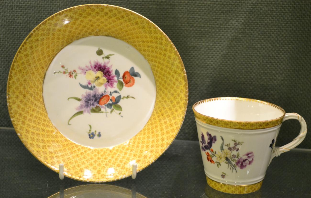 A Meissen Porcelain Cup and Saucer, mid 18th century, of bucket shape with strap handle, painted