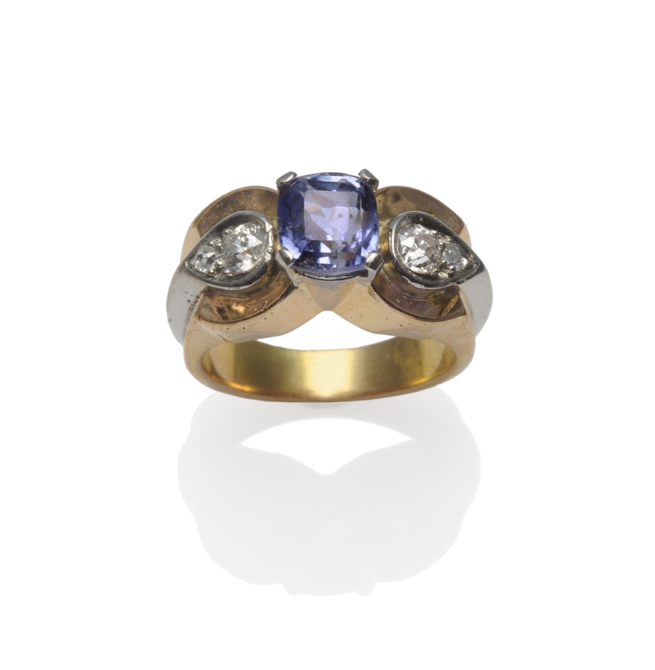 A Sapphire and Diamond Ring, circa 1940, a cushion cut light blue sapphire in a white claw setting,
