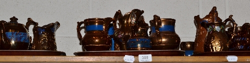A quantity of assorted copper lustre jugs, cups, bowls etc (on one shelf)