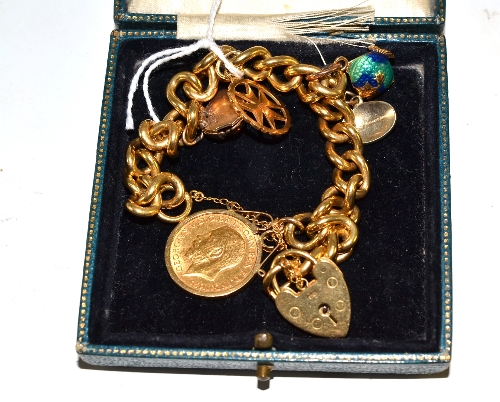 A curb and lock bracelet, stamped `18`, hung with five charms, including a 1911 half sovereign