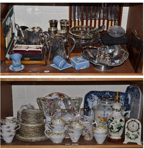Two shelves of ceramics, glass and silver plate including two canteens of cutlery, tea service,