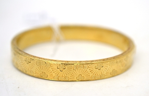 A hinged bangle, with floral decoration Good condition. Tongue and box catch. Tongue stamped `585`.