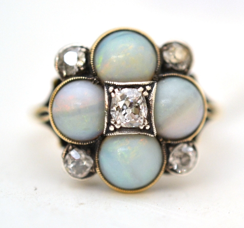 An opal and diamond cluster ring, five old cut diamonds and four round cabochon opals in white and