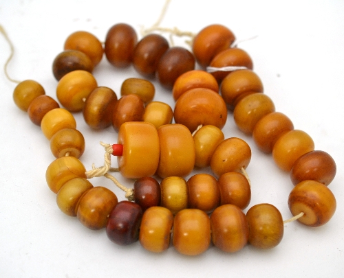 Two strands of amber beads, and one loose bead, of orangey-yellow colour Gross weight 309.8 grams.