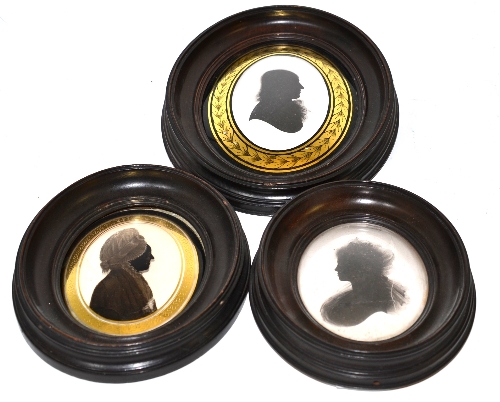 A reverse painted oval silhouette portrait on glass, depicting an elderly woman, in the manner of