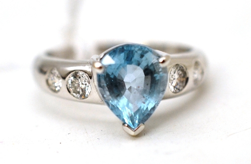 An aquamarine and diamond ring, a pear mixed cut aquamarine in a white claw setting, to shoulders