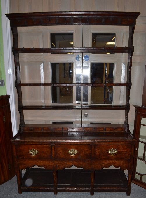 An 18th century English oak open dresser and rack, with three fixed shelves and iron cup hooks