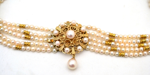 A cultured pearl choker, five rows of cultured pearls with bow style spacers, to a round decorative