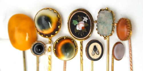 Nine assorted stick pins, set with assorted stones including amber, pietra dura examples, operculum