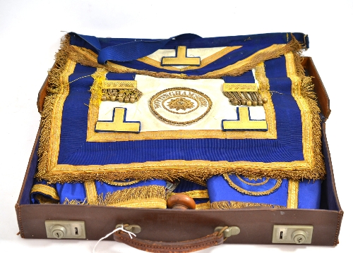 A collection of Masonic regalia comprising apron, a pair of cuffs, sash with silver gilt jewel, a