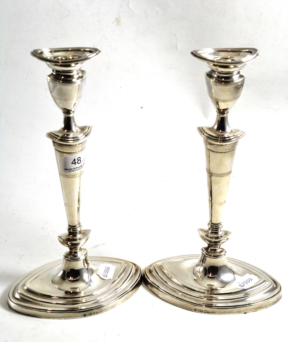 A pair of silver loaded candlesticks, London 1930