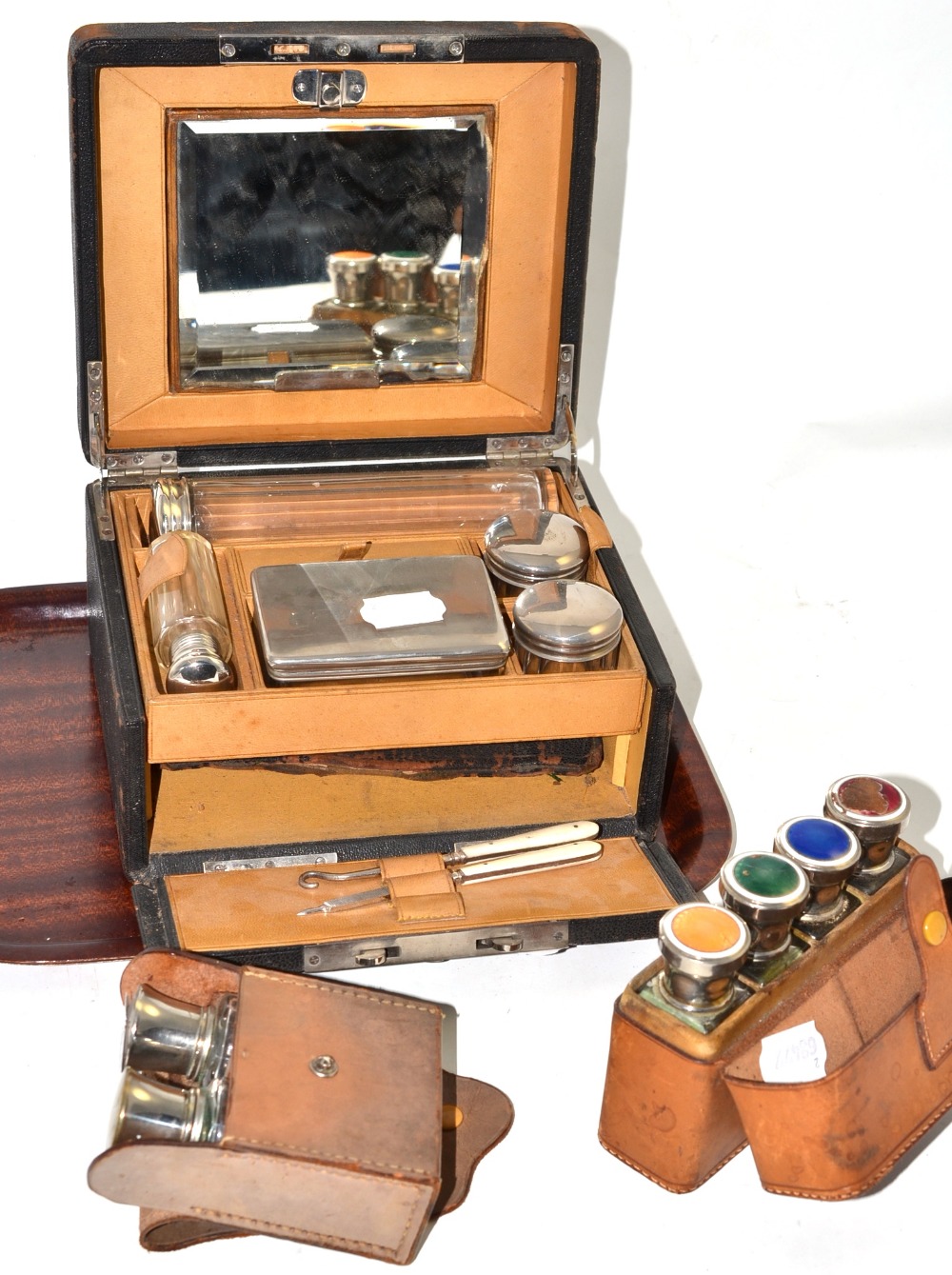 A leather travelling dressing case with glass plated fittings, a cased set of toilet bottles with