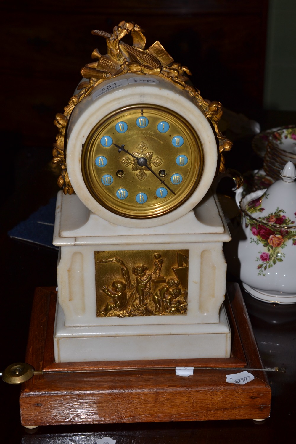 A white marble mantel clock with blue Roman numerals, with wooden base, key and pendulum