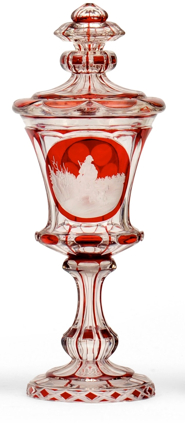 A Bohemian Ruby Flashed Goblet and Cover, mid 19th century, of panelled form, engraved with a