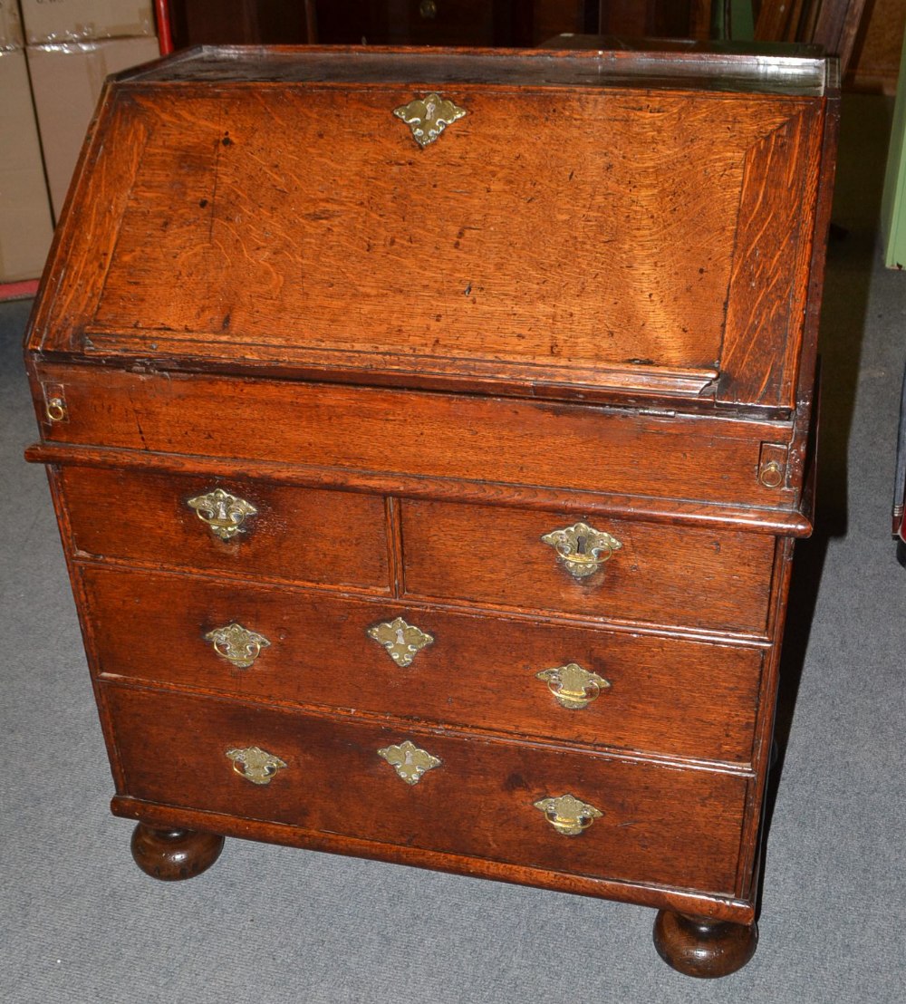An Early 18th Century Oak Bureau, of small proportions, the fall enclosing an attractive fitted