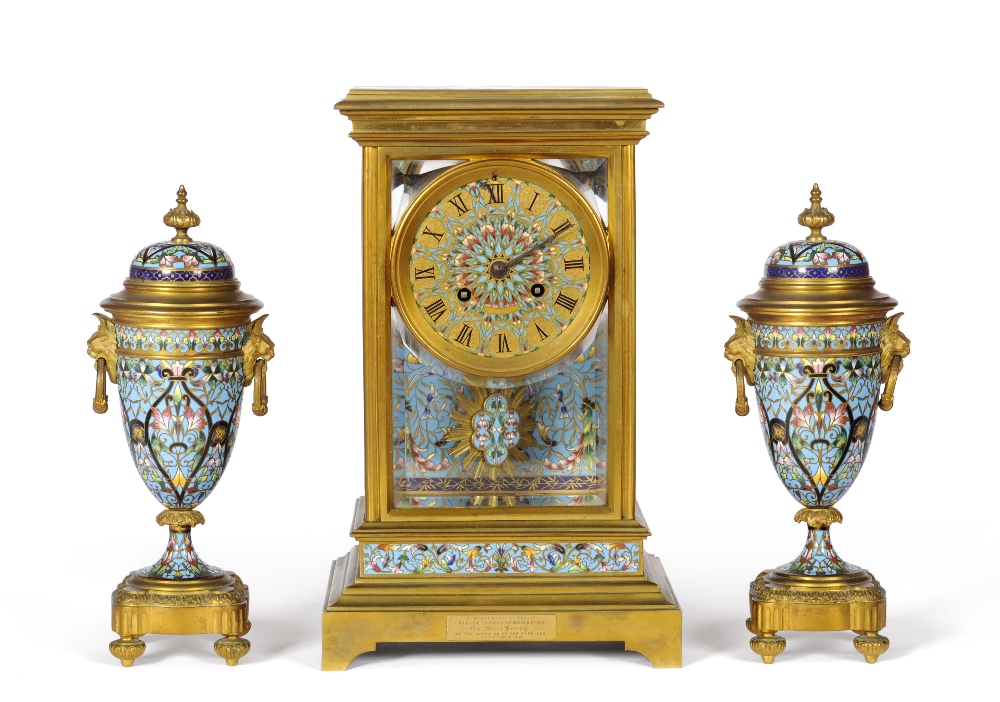 A Gilt Brass Champleve Enamel Striking Mantel Clock with Garniture, circa 1880, with bevelled glass