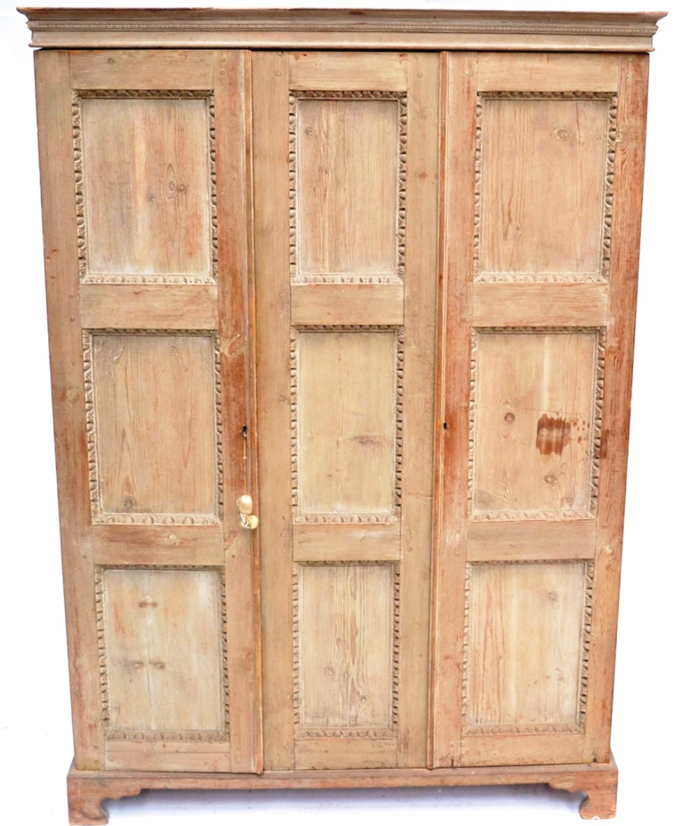 A 19th Century Limed Oak Triple Door Cupboard, with egg and dart carved moulding and nine panels,